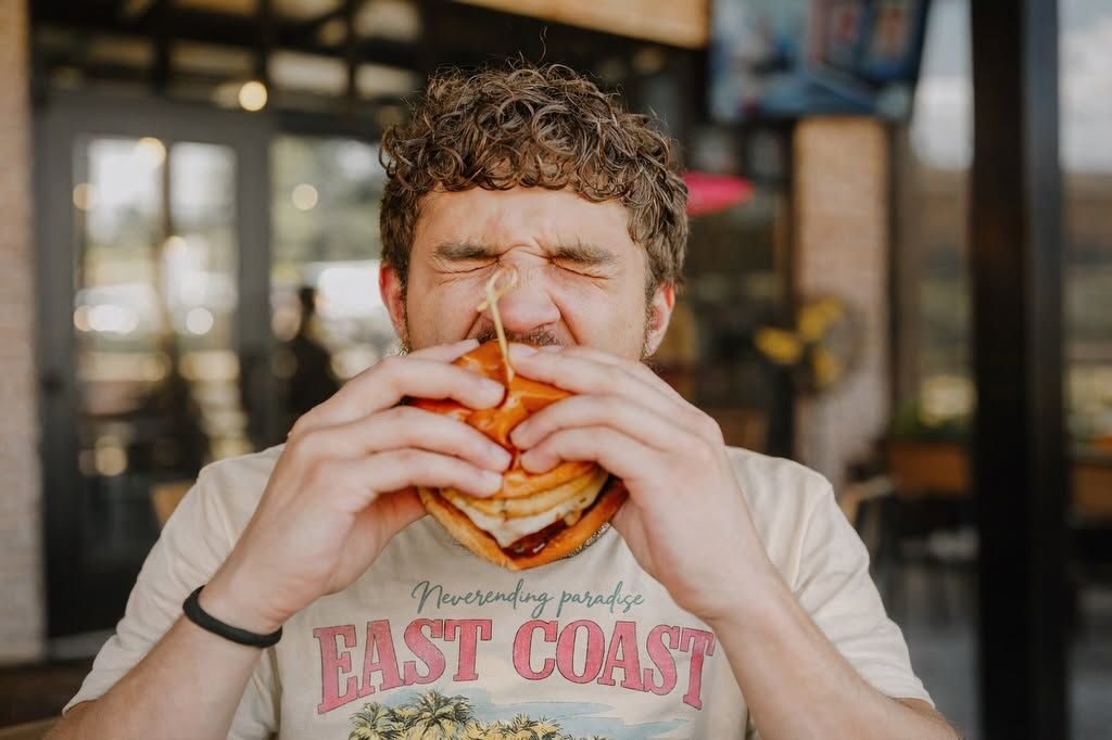 Guest taking a huge bite of a Brinks Tavern burger